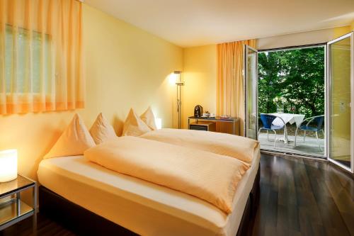 BeinwilBeinwil Swiss Quality Seehotel的酒店客房设有一张床和一个大窗户