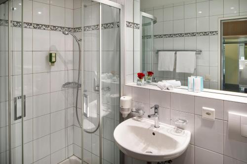 BeinwilBeinwil Swiss Quality Seehotel的白色的浴室设有水槽和淋浴。