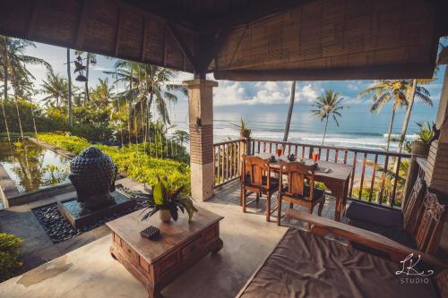 塞莱马德加努玛珍巴厘岛别墅酒店的一个带桌子并享有海景的门廊