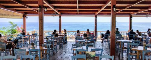 阿吉亚努美利吉格罗斯旅馆的一家餐厅,有坐在海滩桌子旁的人