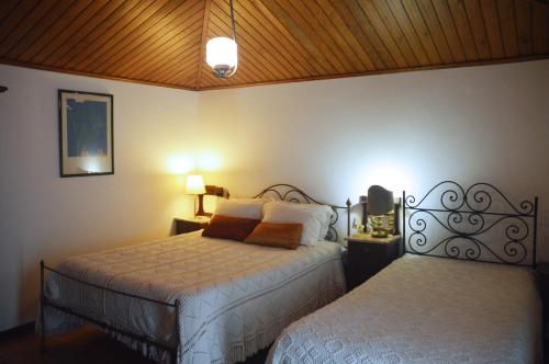 Viatodos卡萨卡瓦略农家乐的一间卧室配有两张床和两盏灯。