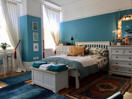 泰恩河畔纽卡斯尔Sidney Grove B&B的一间卧室设有一张床和蓝色的墙壁