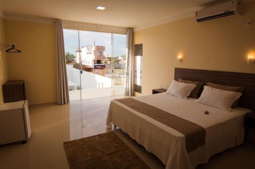 马卡帕ROYAL Hotel & Gastronomia的一间卧室设有一张大床和一个大窗户