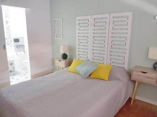 塞图巴尔Casa70的一间卧室配有一张大床,提供黄色和蓝色的枕头