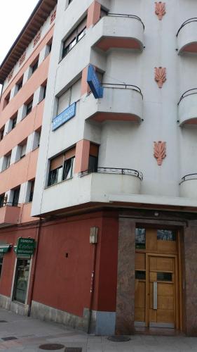 奥维多Hostal González的一座带门的公寓楼和一座大楼