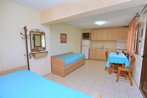 佩科霍里Katerina Apartments的客房设有厨房和一张带蓝色床的桌子。