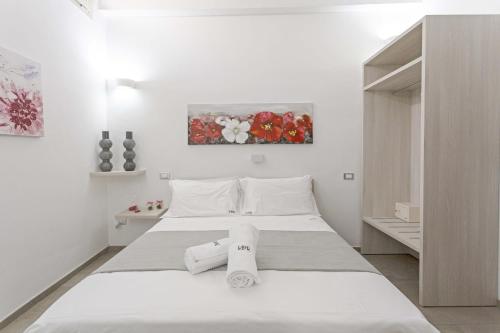 莱切La Loggia dei Raynò的白色卧室,配有带毛巾的床
