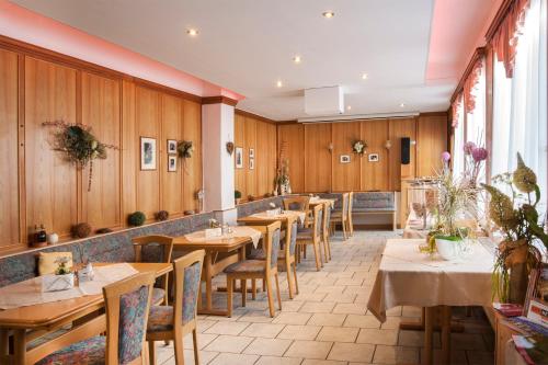 萨尔费尔德Hotel Weltrich的餐厅拥有木墙和桌椅