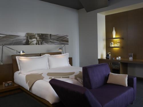 卡尔加里卡尔加里吉门酒店的一间卧室配有一张床和一张紫色椅子