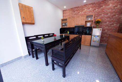芽庄安娜之家旅舍的厨房配有桌椅和冰箱。