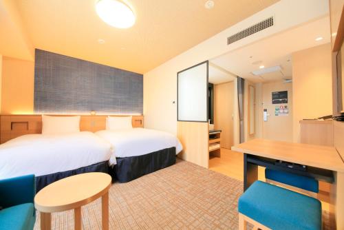 姬路姬路里士满酒店的配有一张床和一张书桌的酒店客房