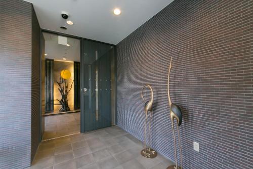 湖西市纳凡浜名湖酒店的一间砖墙和玻璃墙的浴室