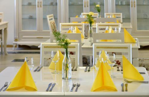 伊萨尔米Hotel Golden Dome Iisalmi的一张桌子,上面有黄色的餐巾和眼镜