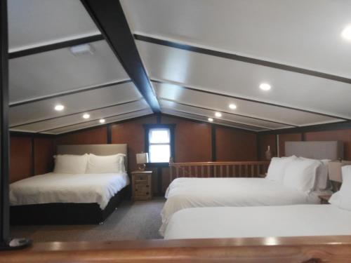 奥兰莫尔The Wild Atlantic Way Barn的客房设有两张床和窗户。