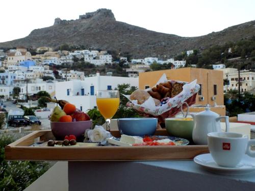 PanteliAnemi Leros Apartments的餐桌上放着一盘食物和饮料,享有美景