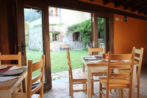 BusturiaEcoHotel Rural Angiz的一间带桌椅和窗户的用餐室