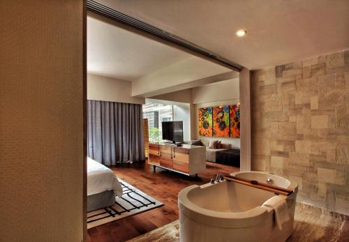 勒吉安塞米亚克巴厘岛TS套房酒店的带浴缸的浴室和卧室