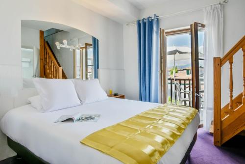 昂代Logis Hotel & Restaurant Bergeret Sport的一间带大床的卧室和一个阳台