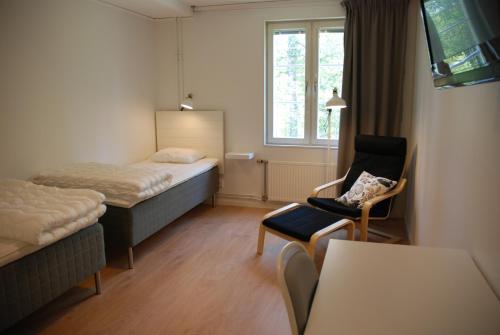于默奥Strömbäcks Vandrarhem的酒店的客房 - 带一张床、椅子和窗户
