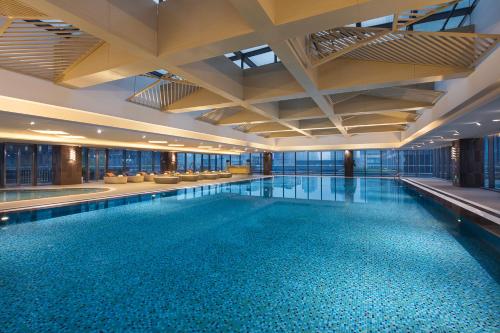 苏州苏州盛捷白塘金融港服务公寓的一座大型游泳池,位于一座拥有大型天花板的建筑内