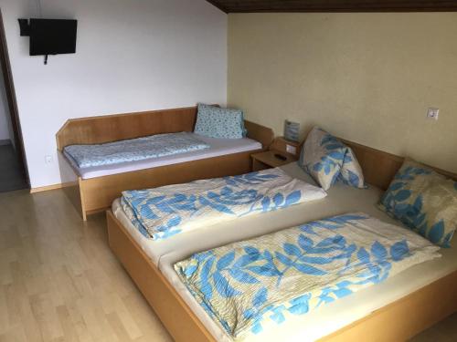 费尔德基兴Gasthof Wadl的客房设有两张床和一台墙上的电视。