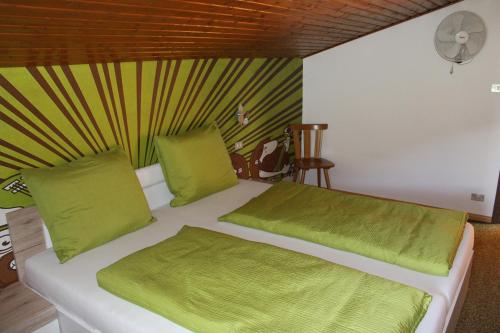 卢松Watscherhof的客房内的白色床、绿色床单和枕头