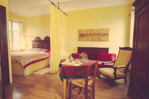 PortacomaroAntica Casa Nebiolo的卧室配有一张床和一张桌子及椅子