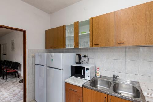 莫鲁纳特Villa Marija - Sea View Rooms的厨房配有水槽和白色冰箱