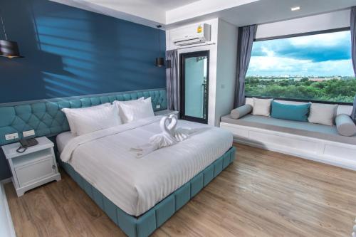 乌隆他尼豪斯屋栋塔尼酒店的一间卧室设有一张床和一个大窗户