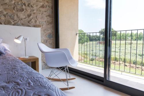 圣格雷戈里奥Can Parés的卧室配有白色椅子和大窗户