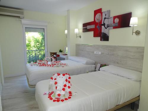 瓜达拉哈拉Pensión El Otero 2的酒店客房,配有两张带鲜花的床
