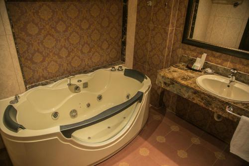 贝鲁特皇后套房酒店的一间带大浴缸和水槽的浴室