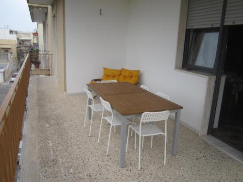 滨海波利尼亚诺Casa Raffaella的阳台上的木桌和椅子