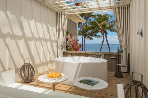 基拉戈Bungalows Key Largo - All Inclusive的带浴缸的浴室,享有海景。