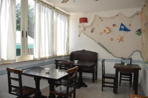 萨包迪亚Il Grifo的一间设有桌椅的用餐室和一张墙上的地图