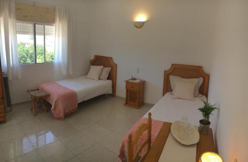 桑卢卡尔-德巴拉梅达Casa Algaida的一间卧室设有两张床、一张桌子和一个窗口