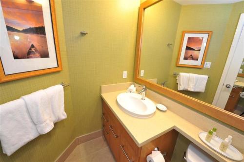 奥索尤斯水印海滩度假村的一间带水槽和镜子的浴室