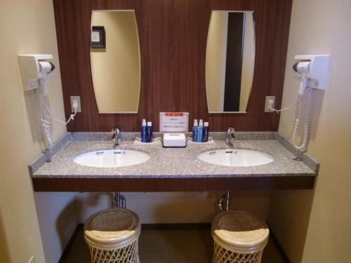 琴平町琴平町河畔酒店的浴室设有2个水槽和2面镜子