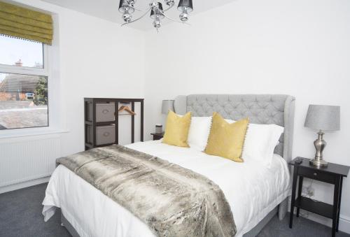 卡莱尔The Annex的一间卧室配有白色床和黄色枕头