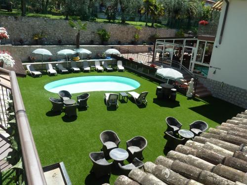 布雷佐内加尔达艾斯特之家住宿酒店的享有带椅子和桌子的游泳池的上方景色