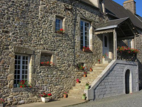 Tourville-sur-SienneLe haut Manoir的一座石头建筑,楼梯上放着花盒