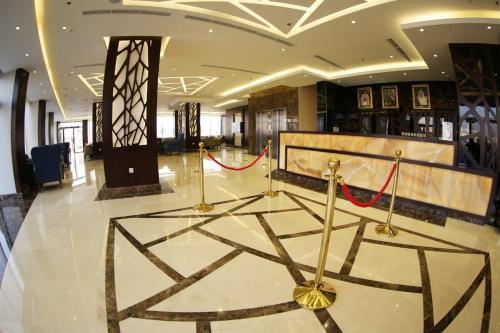 阿可贺巴SAS Al Olaya Hotel Suites的大堂设有红色的带状带的大型大堂