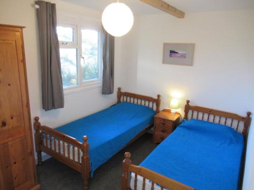 波斯陶恩Mount Hawke Holiday Bungalows的一间卧室设有两张床和窗户。