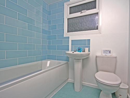 波斯陶恩Mount Hawke Holiday Bungalows的浴室配有卫生间、盥洗盆和浴缸。