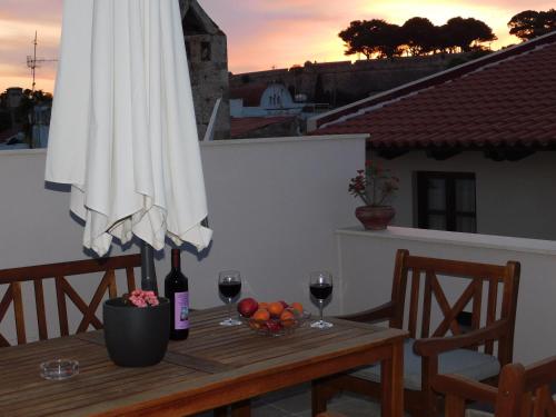 罗希姆诺Onar Superior Suites的一张桌子,上面有雨伞和两杯葡萄酒