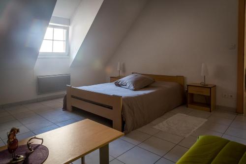 Orschwihr弗格勒尔住宿加早餐旅馆的一间卧室配有一张床、一张桌子和一个窗户。