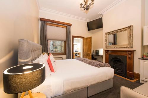马奇美吉帕克维酒店的一间卧室配有一张床、一把椅子和一个壁炉