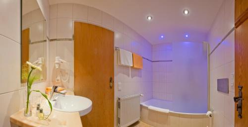 施万高胡伯霍夫兰德酒店的浴室配有盥洗盆和浴缸。