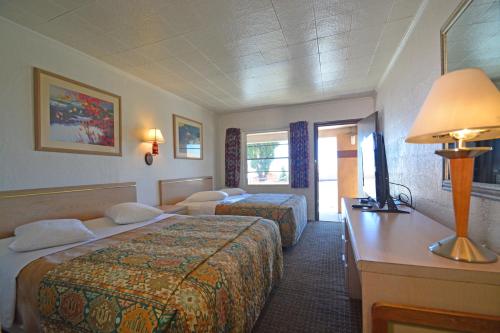 弗拉格斯塔夫Western Hills Motel的酒店客房配有两张床和一张书桌