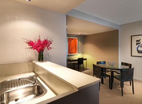 悉尼悉尼情人港阿迪娜公寓式酒店的厨房以及带水槽和桌子的用餐室